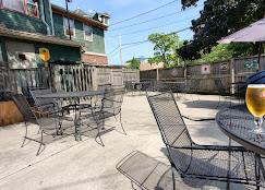 The Beacon Pub beer garden — wrought-iron tables on a concrete patio behind the green clapboard pub